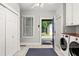 Functional laundry room with washer, dryer, tile floor, and access to the backyard at 608 Hardendorf Ne Ave, Atlanta, GA 30307