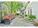 Stone backyard patio featuring multiple seating areas, lush landscaping, and exterior home lighting at 907 Eden Se Ave, Atlanta, GA 30316