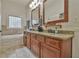 Bathroom featuring double vanity with granite counters, wooden cabinets, separate tub, and decor items at 907 Eden Se Ave, Atlanta, GA 30316