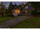 Exterior view of the home showcasing a long driveway, two-car garage, and well-lit entrance at dusk at 907 Eden Se Ave, Atlanta, GA 30316