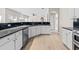 Open kitchen with stainless steel appliances, black countertops, and bright, light-colored wood flooring at 2030 Brook Meadow Dr, Alpharetta, GA 30005