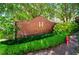 Brick entrance to Heritage Place condominium complex with lush landscaping and mature shade trees at 211 Colonial Homes Nw Dr # 2304, Atlanta, GA 30309