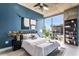 Modern bedroom with an exposed concrete ceiling, blue accent wall, and cityscape views at 855 Peachtree Ne St # 2309, Atlanta, GA 30308