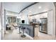 Modern kitchen with white cabinets, stainless steel appliances, a bar counter, and an open view to the living room at 855 Peachtree Ne St # 2309, Atlanta, GA 30308