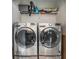 Laundry room with modern side-by-side washer and dryer and a shelf above them, perfect for easy laundry at 855 Peachtree Ne St # 2309, Atlanta, GA 30308