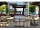 Outdoor kitchen with a stainless steel grill, bar seating, and views of the surrounding cityscape at 855 Peachtree Ne St # 2309, Atlanta, GA 30308