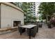 Outdoor patio area showcasing a stone fireplace, a dining table and a built-in grill with beautiful landscaping at 855 Peachtree Ne St # 2309, Atlanta, GA 30308