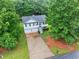 Aerial view of the home featuring the driveway, garage, and manicured lawn at 240 Mountain Ln, Covington, GA 30016