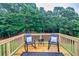 Back deck with two rocking chairs and black accent table overlooking a wooded area at 240 Mountain Ln, Covington, GA 30016