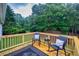 Back deck with two rocking chairs and black accent table overlooking a wooded area at 240 Mountain Ln, Covington, GA 30016