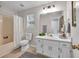 Bathroom features a shower-tub combo with a neutral vanity, and a large mirror at 240 Mountain Ln, Covington, GA 30016