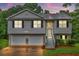 Charming split-level home featuring a two-car garage and inviting front porch at sunset at 240 Mountain Ln, Covington, GA 30016