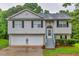 Charming split-level home featuring a two-car garage and inviting front porch at 240 Mountain Ln, Covington, GA 30016