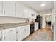Bright kitchen with white cabinets, granite countertops, and stainless steel appliances at 240 Mountain Ln, Covington, GA 30016
