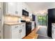 Bright kitchen features white cabinets, black appliances, light countertops, and hardwood floors at 2960 Cedar Knoll Dr, Roswell, GA 30076