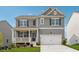 Charming two-story home featuring gray siding, black shutters, a covered porch, and an attached two-car garage at 96 Quail Bend Way, Dallas, GA 30157