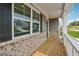 Inviting front porch with brick accents, white railing, wood decking, and views of the neighborhood at 96 Quail Bend Way, Dallas, GA 30157