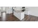 Open concept kitchen featuring white cabinets, granite countertops, stainless steel appliances, and hardwood floors at 96 Quail Bend Way, Dallas, GA 30157