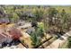 Aerial view of home near a pond, showcasing mature trees and landscaping, offering a serene and private setting at 13090 Magnolia Crescent Dr, Roswell, GA 30075