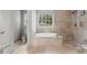 Elegant bathroom showcasing a soaking tub, tiled shower, and natural stone finishes at 13090 Magnolia Crescent Dr, Roswell, GA 30075