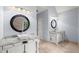 Bathroom featuring dual sinks with granite countertops and decorative framed mirrors at 13090 Magnolia Crescent Dr, Roswell, GA 30075