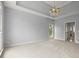 Spacious bedroom featuring plush carpeting, tray ceilings, and a chandelier at 13090 Magnolia Crescent Dr, Roswell, GA 30075