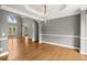 Dining area with hardwood floors, chandelier, wainscoting, and views of the front yard through large windows at 13090 Magnolia Crescent Dr, Roswell, GA 30075