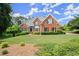 Beautiful brick home with a well-maintained lawn and lush landscaping, creating a welcoming curb appeal at 13090 Magnolia Crescent Dr, Roswell, GA 30075