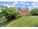 Charming brick two-story home featuring manicured landscaping and a well-maintained lawn at 13090 Magnolia Crescent Dr, Roswell, GA 30075