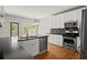 Well-equipped kitchen with stainless steel appliances, granite countertops, and hardwood floors, perfect for cooking at 13090 Magnolia Crescent Dr, Roswell, GA 30075