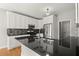 Updated kitchen boasts stainless steel appliances, granite countertops, mosaic backsplash, and hardwood floors at 13090 Magnolia Crescent Dr, Roswell, GA 30075