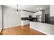 Modern kitchen featuring white cabinets, stainless steel appliances, granite countertops, and hardwood floors at 13090 Magnolia Crescent Dr, Roswell, GA 30075