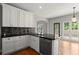 Charming kitchen features granite countertops, stainless steel appliances, white cabinets, and hardwood floors at 13090 Magnolia Crescent Dr, Roswell, GA 30075