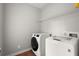 Functional laundry area with modern washer and dryer units and convenient storage at 13090 Magnolia Crescent Dr, Roswell, GA 30075