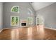 Spacious living room with hardwood floors, fireplace, tall windows, and access to outdoor area at 13090 Magnolia Crescent Dr, Roswell, GA 30075