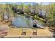 Picturesque pond view with a gazebo and benches, surrounded by lush greenery and trees on a sunny day at 13090 Magnolia Crescent Dr, Roswell, GA 30075
