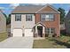 Charming two-story home with brick and siding, featuring a two-car garage and well-maintained front lawn at 1152 Werre Way, Locust Grove, GA 30248
