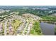 Aerial view showcasing the neighborhood, surrounding trees, and a tranquil lake near the community at 4650 Orchard View Way, Cumming, GA 30028