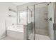 Bathroom featuring tub, glass-enclosed shower with built in seating, neutral tile, and built-in shelves at 4650 Orchard View Way, Cumming, GA 30028