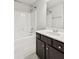 Bathroom with a bath tub, shower, dark wood cabinets, and white countertop at 4650 Orchard View Way, Cumming, GA 30028
