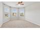 This bedroom features a carpet, light grey walls and multiple windows overlooking the neighborhood at 4650 Orchard View Way, Cumming, GA 30028