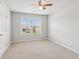 A carpeted bedroom features a ceiling fan and a window looking out to the neighborhood at 4650 Orchard View Way, Cumming, GA 30028