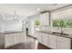Bright kitchen with white cabinets, granite countertops, stainless steel appliances, and view to living area at 4650 Orchard View Way, Cumming, GA 30028