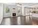 Open living room flows to the kitchen, featuring hardwood floors and a fireplace at 4650 Orchard View Way, Cumming, GA 30028