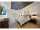 A spacious main bedroom with a tray ceiling, dark wood furniture, and shuttered windows at 7165 Cordery Rd, Cumming, GA 30040
