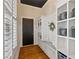 A mudroom with built-in storage, bench seating, and dark-stained wood floors at 7165 Cordery Rd, Cumming, GA 30040