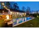 Backyard pool featuring fire bowls, charming pool house, and cozy outdoor seating under string lights at 7165 Cordery Rd, Cumming, GA 30040
