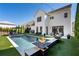 Daytime view of the backyard pool, showcasing a fire pit, patio seating, and pristine landscaping at 7165 Cordery Rd, Cumming, GA 30040
