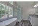 Bathroom featuring a soaking tub, glass-enclosed shower, and scenic views from the large window at 863 Fairlong Nw Way, Acworth, GA 30101