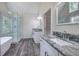 Bathroom featuring marble countertops, dual vanities, glass enclosed shower, and a modern soaking tub at 863 Fairlong Nw Way, Acworth, GA 30101